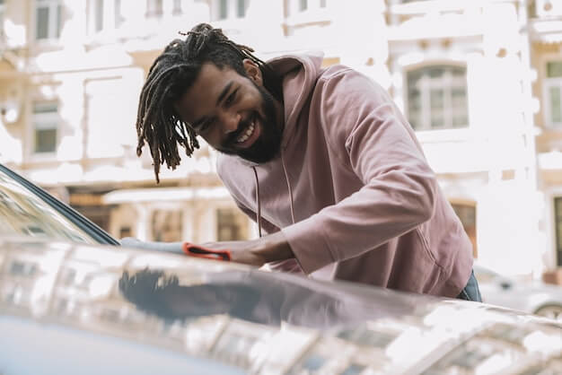 Free photo happy man cleaning car front view