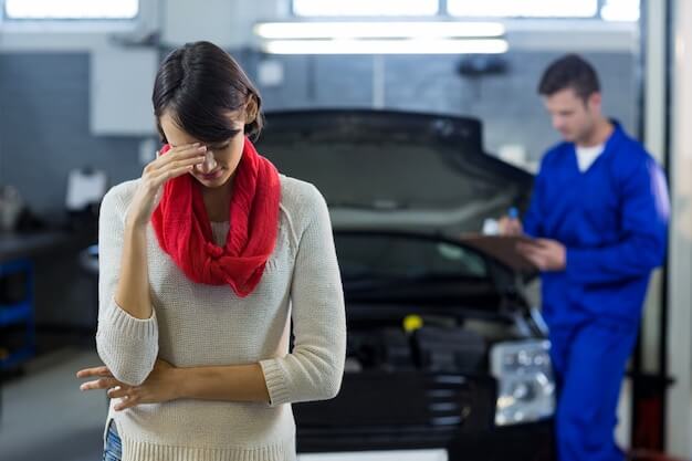 Free photo worried customer standing while mechanic examining car in background