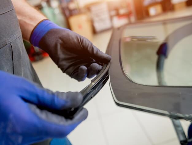 Photo automobile special workers replacing windscreen of a car in auto service station