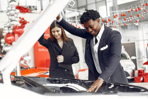 Free photo handsome and elegant black man in a car salon