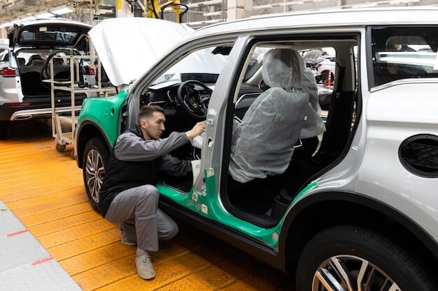 Free photo minsk belarus dec 15 2021 car bodies are on assembly line factory for production of cars modern automotive industry electric car factory conveyor workers