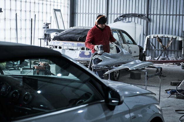 Photo car service worker repairs restores car