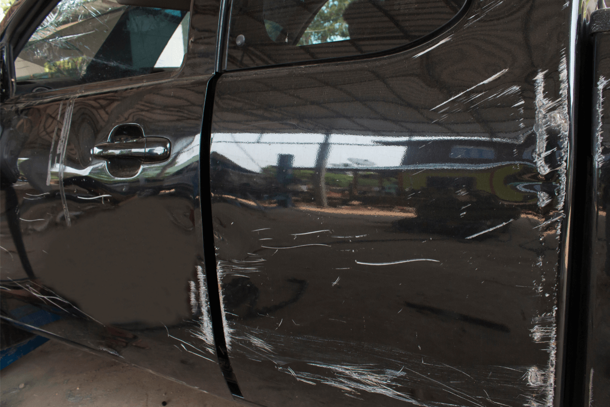 égratignure carrosserie voiture noire brillante après accident